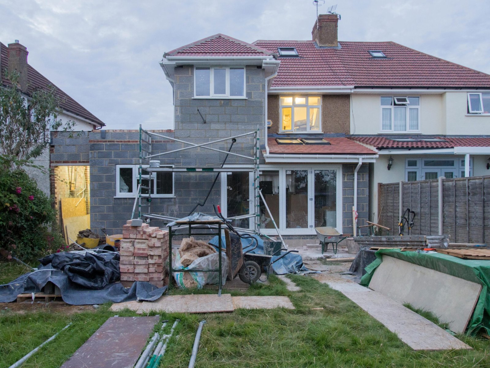 Rear home addition under construction on a brick house