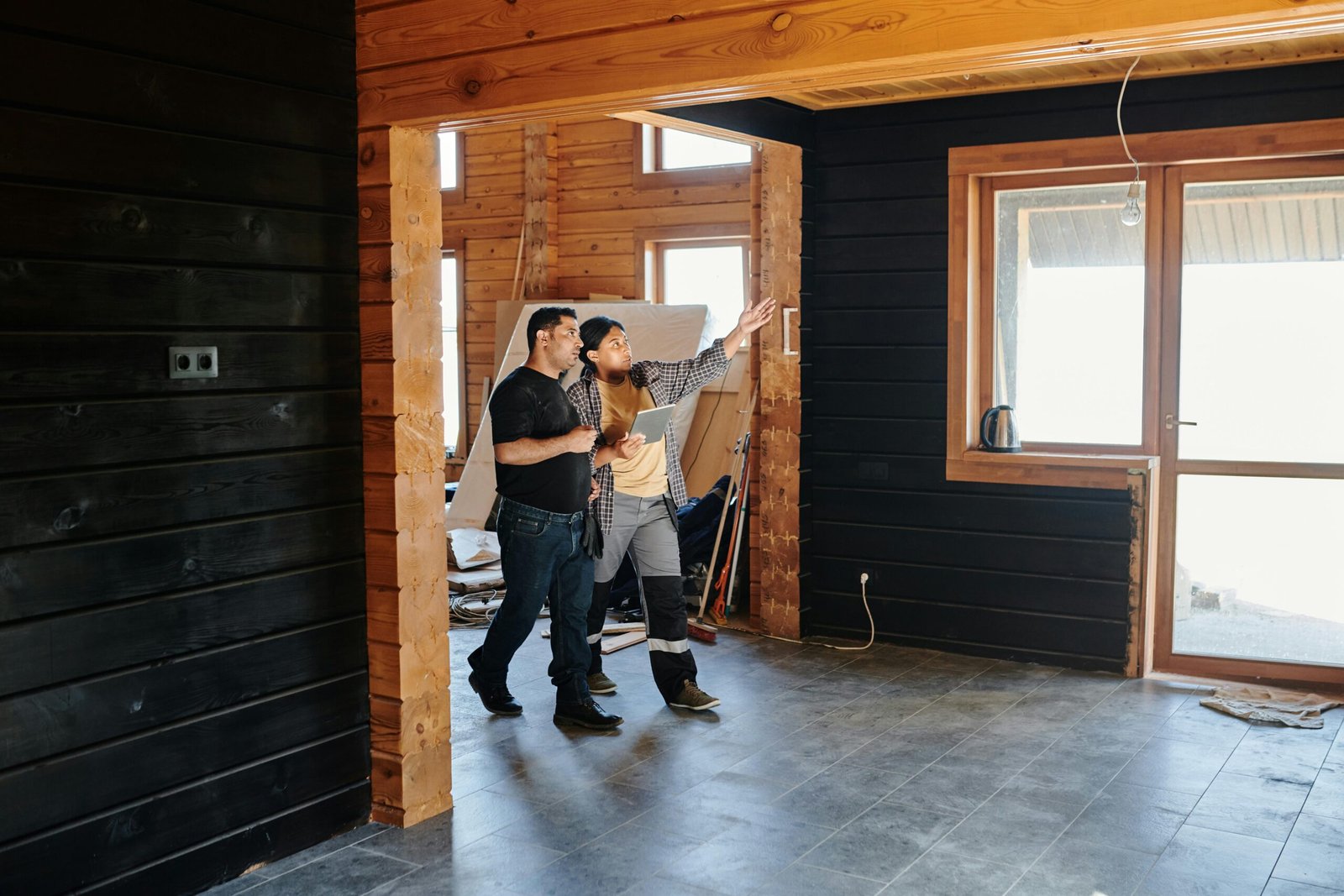 Contractors reviewing plans inside a space under renovation